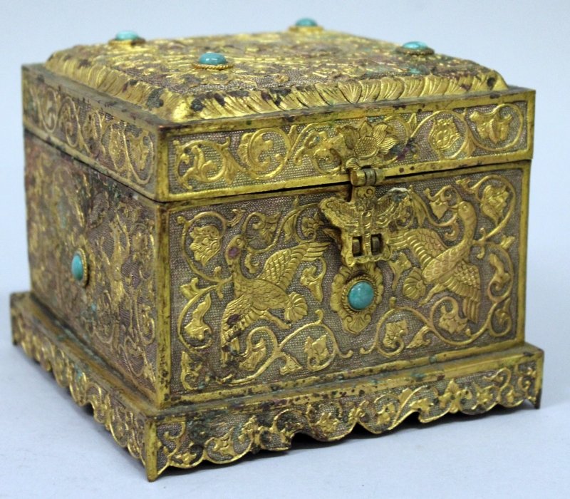 A CHINESE TANG STYLE GILT METAL CASKET, 19th Century or: A CHINESE TANG STYLE GILT METAL CASKET, 19th Century or earlier, of square section with a hinged cover, each surface inset with green stones and embossed with various mythical animals, birds and with 