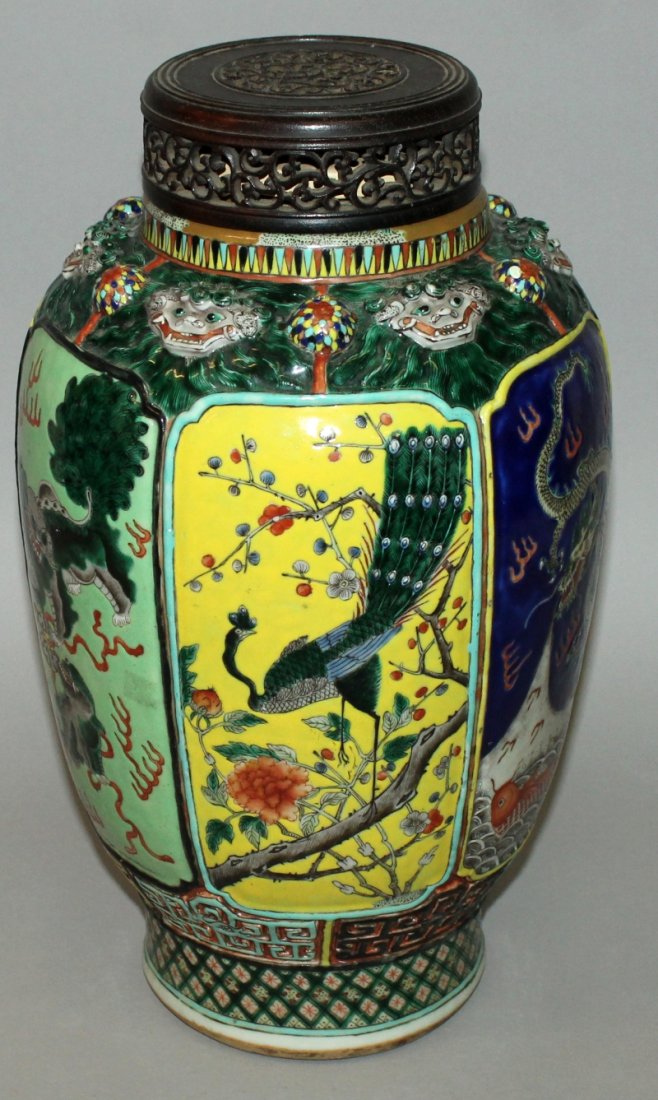 A LARGE 19TH CENTURY CHINESE FAMILLE VERTE PORCELAIN: A LARGE 19TH CENTURY CHINESE FAMILLE VERTE PORCELAIN VASE, together with a fitted carved wood cover, the sides painted with alternating panels of peacocks, dragons and buddhistic lions, the shoulders 