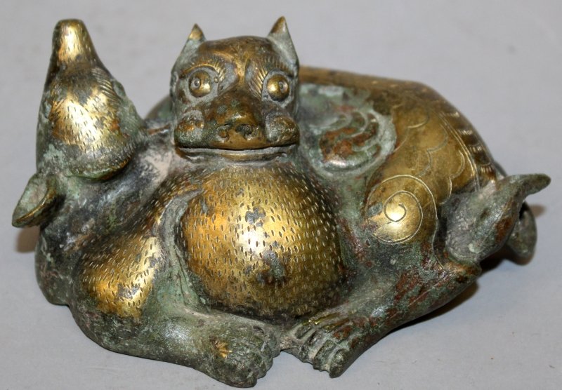 A CHINESE TANG STYLE GILT BRONZE MODEL, of two entwined: A CHINESE TANG STYLE GILT BRONZE MODEL, of two entwined mythical animals, 5in long & 2.4in high.