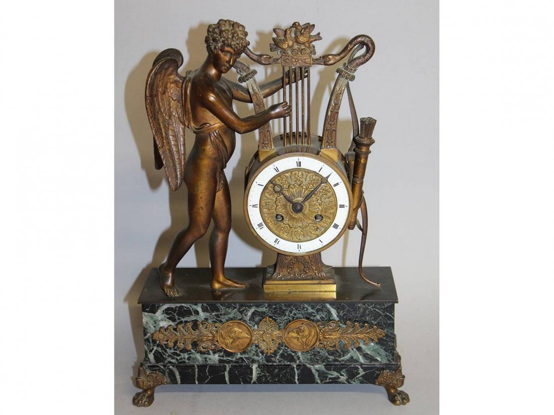 A GOOD FRENCH EMPIRE DRUM MANTLE CLOCK with classical: A GOOD FRENCH EMPIRE DRUM MANTLE CLOCK with classical bronze winged figures holding a lyre, the eight-day movement with black and white Roman numerals, striking on a single bell with grey marble base