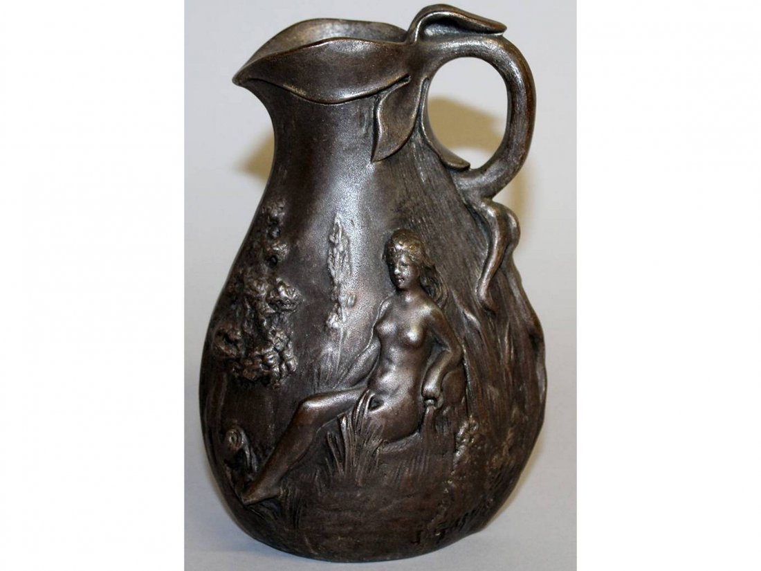 J. GARNIER. AN ART NOUVEAU METAL JUG, repousse with: J. GARNIER. AN ART NOUVEAU METAL JUG, repousse with two nude seated female figures. Signed. 6.5ins high.