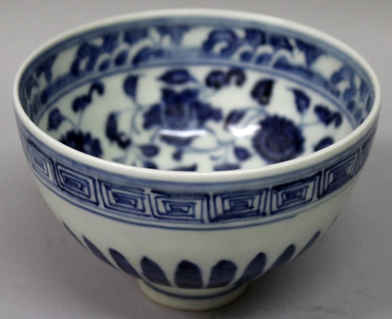 A CHINESE MING STYLE BLUE & WHITE PORCELAIN BOWL, the: A CHINESE MING STYLE BLUE & WHITE PORCELAIN BOWL, the interior with scrolling foliage, the bowl supported on a relatively tall foot, 4.8in diameter & 3.25in high.