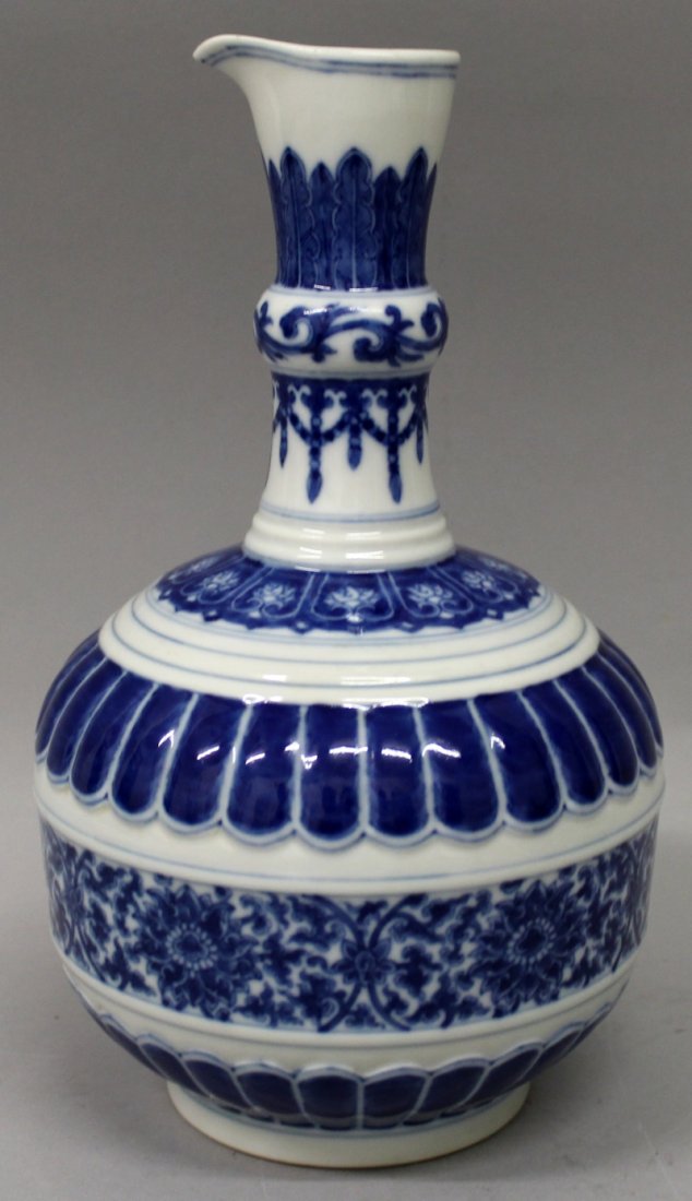 A CHINESE BLUE & WHITE MOULDED PORCELAIN EWER,: A CHINESE BLUE & WHITE MOULDED PORCELAIN EWER, decorated with multiple formal foliate bands and borders, the base with a Qianlong seal mark, 9.8in high.