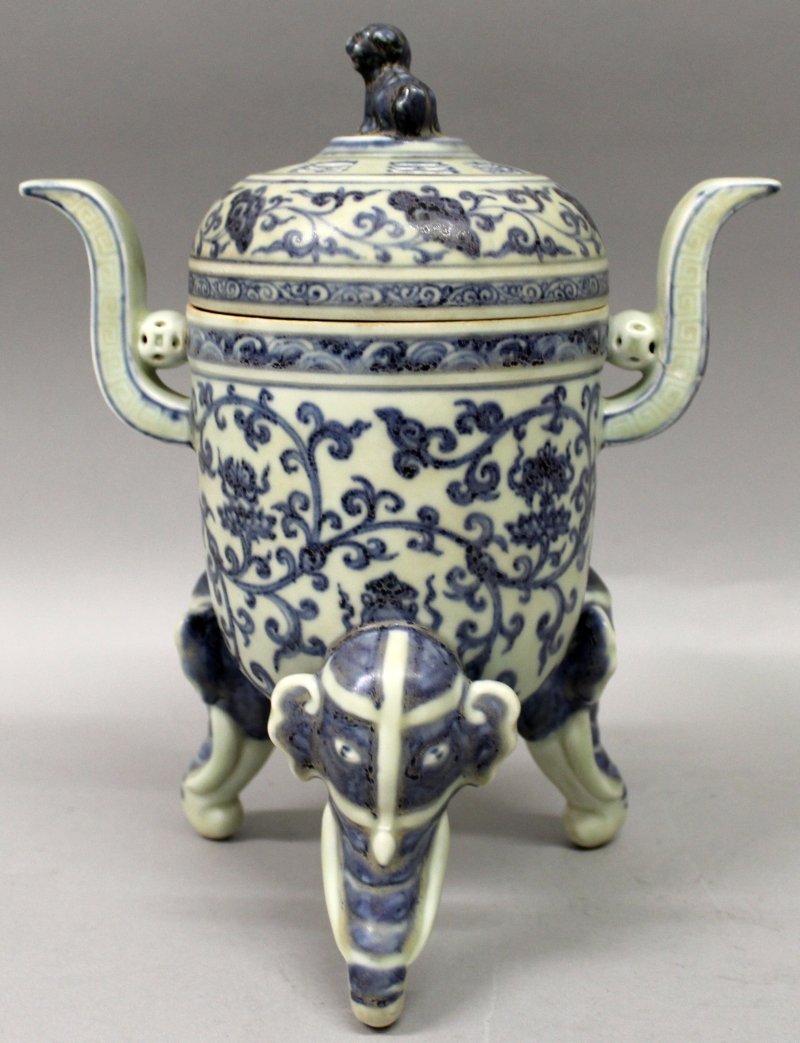 A CHINESE MING STYLE BLUE & WHITE PORCELAIN TRIPOD: A CHINESE MING STYLE BLUE & WHITE PORCELAIN TRIPOD CENSER & COVER, the sides decorated with scrolling lotus, the cover pierced with the Eight Trigrams, the feet in the form of elephant’s heads, the 