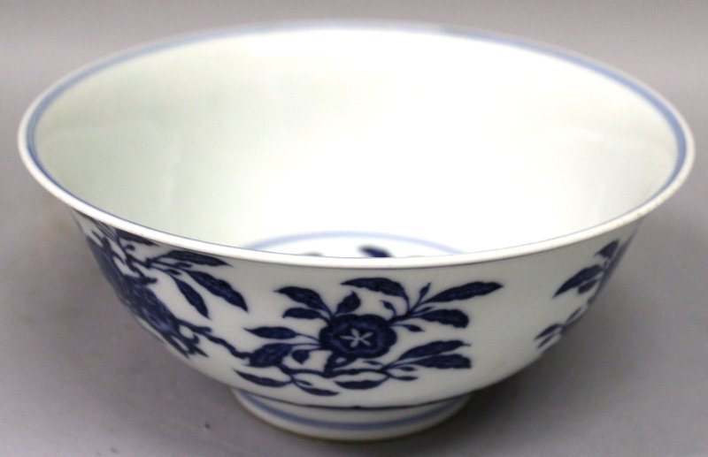 A CHINESE MING STYLE BLUE & WHITE PORCELAIN BOWL, the: A CHINESE MING STYLE BLUE & WHITE PORCELAIN BOWL, the sides decorated with sprays of extended fruit above a lappet border to the foot, the base with a Qianlong seal mark, 7.3in diameter & 3.3in high.