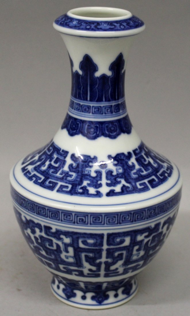 A GOOD QUALITY CHINESE MING STYLE BLUE & WHITE: A GOOD QUALITY CHINESE MING STYLE BLUE & WHITE PORCELAIN VASE, the sides decorated with stylised archaic bands of dragons and key-fret, the base with a Qianlong seal mark, 7.75in high.