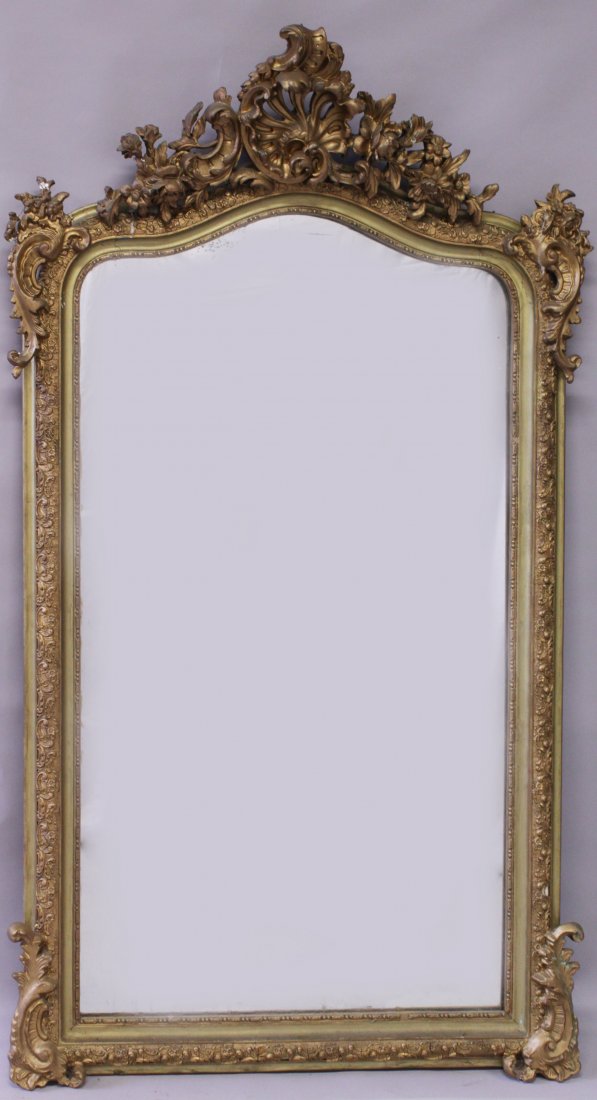 A 19TH CENTURY GILT FRAMED MIRROR, with curving top and: A 19TH CENTURY GILT FRAMED MIRROR, with curving top and ormolu gesso applied decoration. 5ft 0ins high x 2ft 10ins wide.