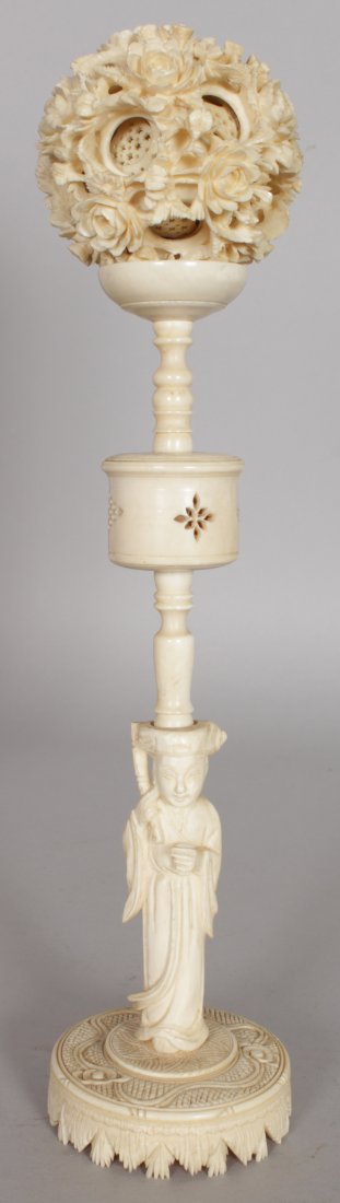 AN EARLY 20TH CENTURY CHINESE CARVED IVORY CONCENTRIC: AN EARLY 20TH CENTURY CHINESE CARVED IVORY CONCENTRIC BALL ON STAND, together with a fitted wood box, the ball's outer sphere carved in deep relief with flowerheads and leafage, the stand in the form 