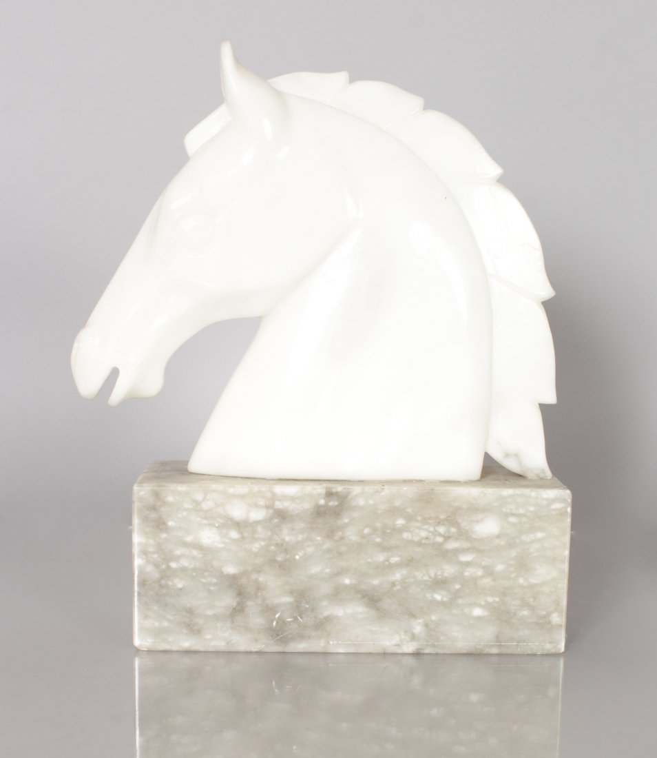 A CARVED WHITE MARBLE HORSES HEAD on a plinth. 11ins: A CARVED WHITE MARBLE HORSES HEAD on a plinth. 11ins high.