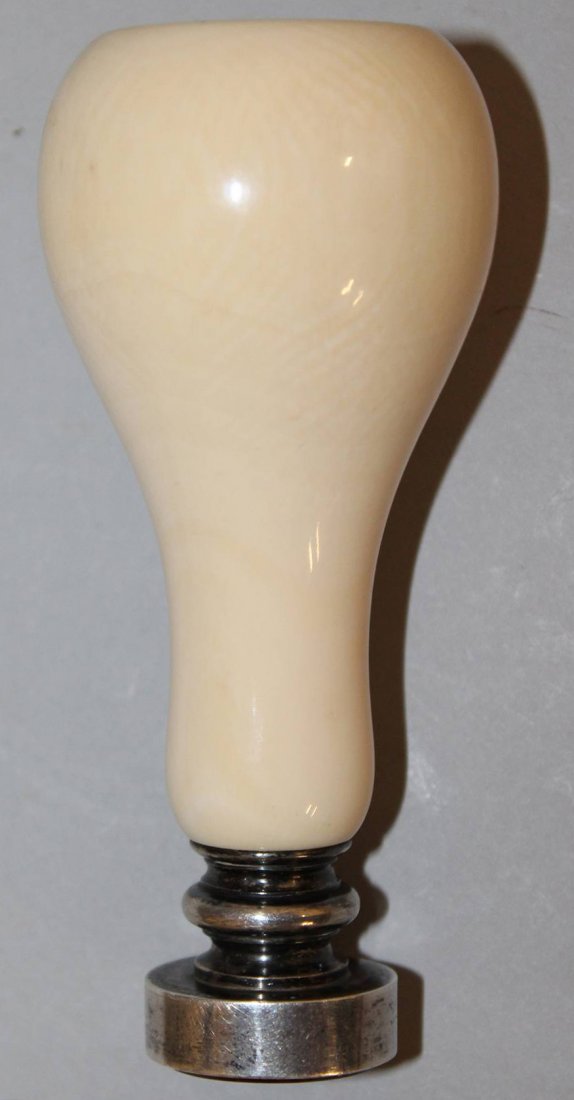 A GOOD TURNED IVORY HANDLED DESK SEAL with oval: A GOOD TURNED IVORY HANDLED DESK SEAL with oval armorial and bloodstone intaglio with plain white metal mounts and bulbous ivory grip. 3.5ins.
