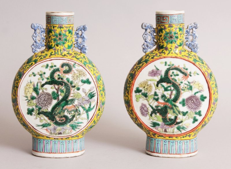 A PAIR OF 19TH CENTURY CHINESE FAMILLE VERTE YELLOW: A PAIR OF 19TH CENTURY CHINESE FAMILLE VERTE YELLOW GROUND PORCELAIN DRAGON MOON FLASKS, each painted with circular panels of a dragon amidst flowers and leafage, the yellow ground embellished with sc