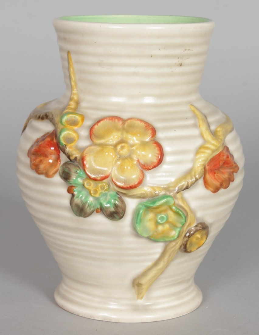 A CLARICE CLIFF VASE, of baluster form, relief: A CLARICE CLIFF VASE, of baluster form, relief decorated with flowers. 7ins high.