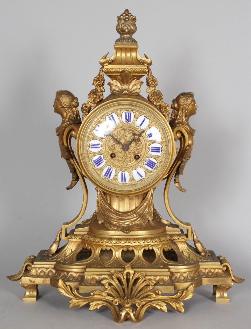 A GOOD LARGE 19TH CENTURY FRENCH ORMOLU MANTLE CLOCK,: A GOOD LARGE 19TH CENTURY FRENCH ORMOLU MANTLE CLOCK, with eight-day movement, the circular dial inset with white and blue enamel numerals, the case surmounted with an urn and female busts. 2ft 0ins h