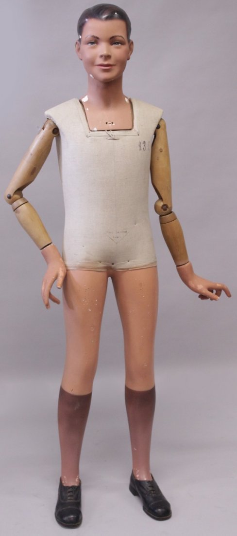 AN UNUSUAL LATE 19TH CENTURY/EARLY 20TH CENTURY FRENCH: AN UNUSUAL LATE 19TH CENTURY/EARLY 20TH CENTURY FRENCH MANNEQUIN, modelled as a boy, with realistically painted plaster head, hands and legs, moveable joints. 4ft 10ins high.