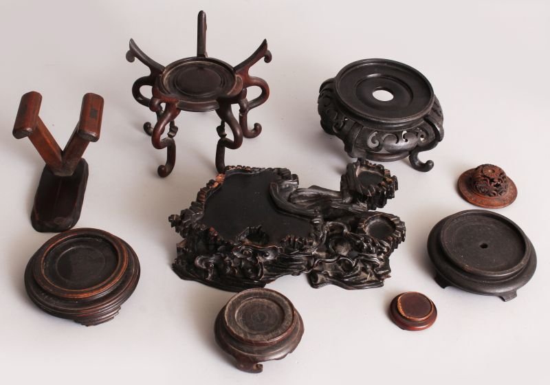 A COLLECTION OF EIGHT CHINESE WOOD STANDS & ONE COVER,: A COLLECTION OF EIGHT CHINESE WOOD STANDS & ONE COVER, various sizes and designs, the largest 8.5in long. (9)
