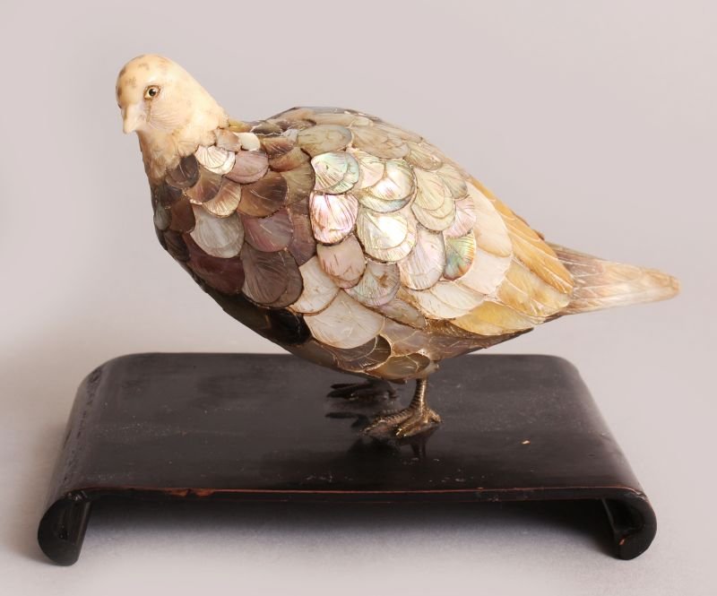 A JAPANESE MEIJI PERIOD MOTHER-OF-PEARL & IVORY MODEL: A JAPANESE MEIJI PERIOD MOTHER-OF-PEARL & IVORY MODEL OF A PIGEON, together with a fixed wood stand, the finely carved ivory head with inlaid eyes, the mother-of-pearl feathers naturalistically engrav