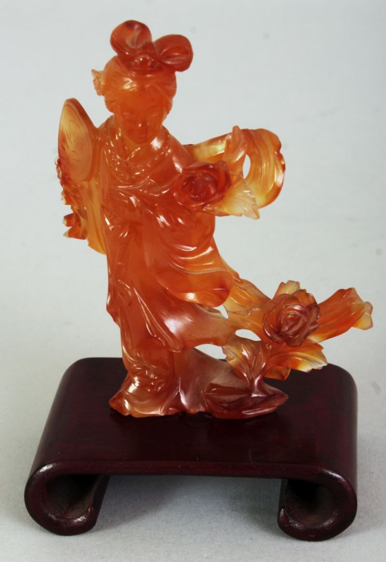 A CHINESE AMBER AGATE CARVING OF GUANYIN, bearing a fan (1 of 5)