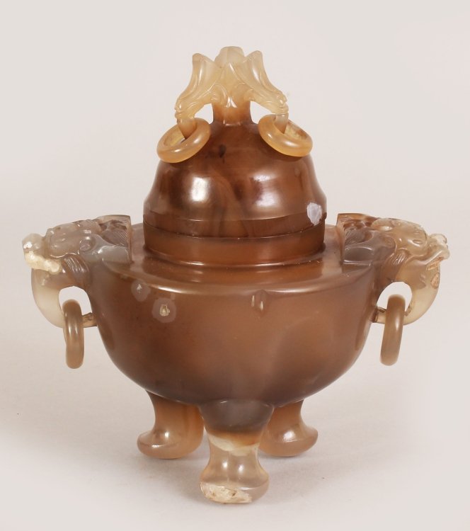 A 19TH/20TH CENTURY CHINESE CARVED AGATE TRIPOD CENSER: A 19TH/20TH CENTURY CHINESE CARVED AGATE TRIPOD CENSER & COVER, with ring handles, the greyish underlying stone with brown inclusions, 5.8in wide including handles & 6in high.