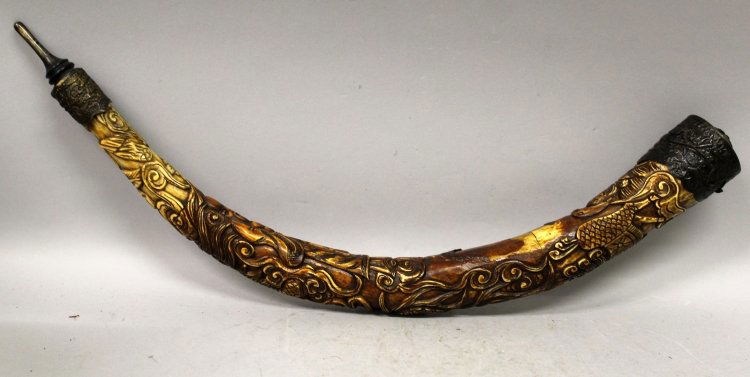 AN EARLY 20TH CENTURY CHINESE SECTIONAL STAINED BONE: AN EARLY 20TH CENTURY CHINESE SECTIONAL STAINED BONE TUSK, with fitted metal end pieces, carved in relief with Shou Lao and a sinuous dragon, 18in long.