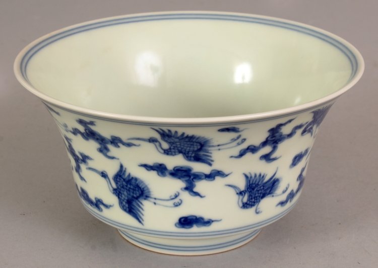 A CHINESE MING STYLE BLUE & WHITE PORCELAIN BOWL, the: A CHINESE MING STYLE BLUE & WHITE PORCELAIN BOWL, the flaring sides decorated with storks in flight amidst cloud scrolls, the base with a six-character Chenghua mark, 5.7in diameter & 3in high.