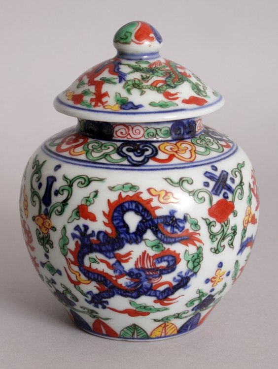 A CHINESE WUCAI PORCELAIN DRAGON JAR & COVER, the base: A CHINESE WUCAI PORCELAIN DRAGON JAR & COVER, the base cast with a six-character Xuande mark, 4.8in high overall.