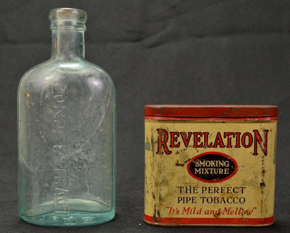 Antique Medicine Bottle & Tobacco Tin: Lot has a glass medicine bottle marked in raised lettering "Pond's Extract" on front and bottom is marked "1846". Bottle has no top and is dirty with some staining. Also included is a Revelation smoki