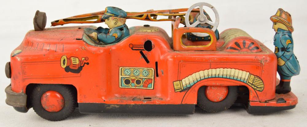 Vintage Pull-back Toy Fire Truck: Vintage pull-back metal toy fire truck. Truck is from an unknown maker. Ladder rails are bent inwards towards the center. Back wheels appear to be part of a pull-back and let go mechanism but are no l