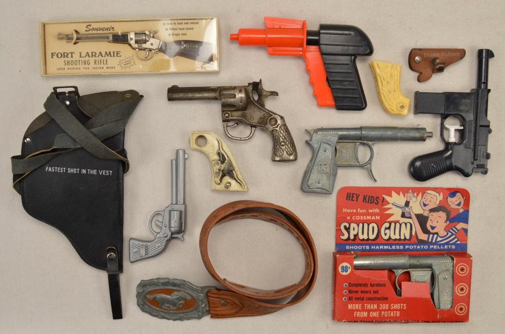 Box Lot of Toy Guns: Includes: Cast iron 22 blank single shot toy gun; mini "Souvenir Fort Laramie Shooting Rifle" in original packaging in very good condition; qty 2 "Cossman Spud Gun" that shoots 'harmless potato pellet