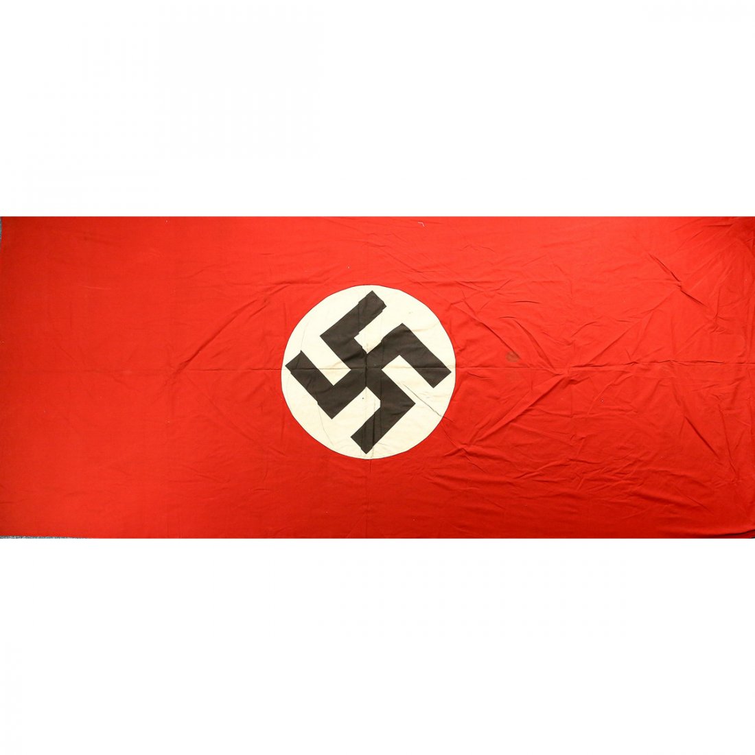 WWII German Banner: A large German banner with a dark stain on the white circle near the swastika. Flag has a few minor stains on the red background with a small hole near one edge as well as a small piece missing near o