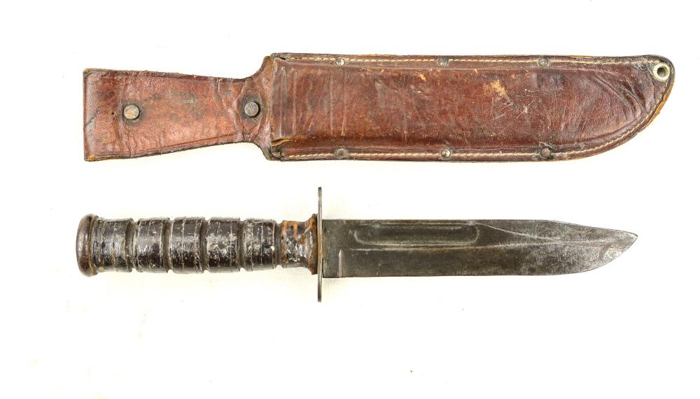 US Fighting Knife: A fighting knife marked “US Camillus” on the ricasso. Tip has been re-sharpened. Blade edge has no nicks or chips and blade retains majority of original finish. Crossguard has worn finish and wood