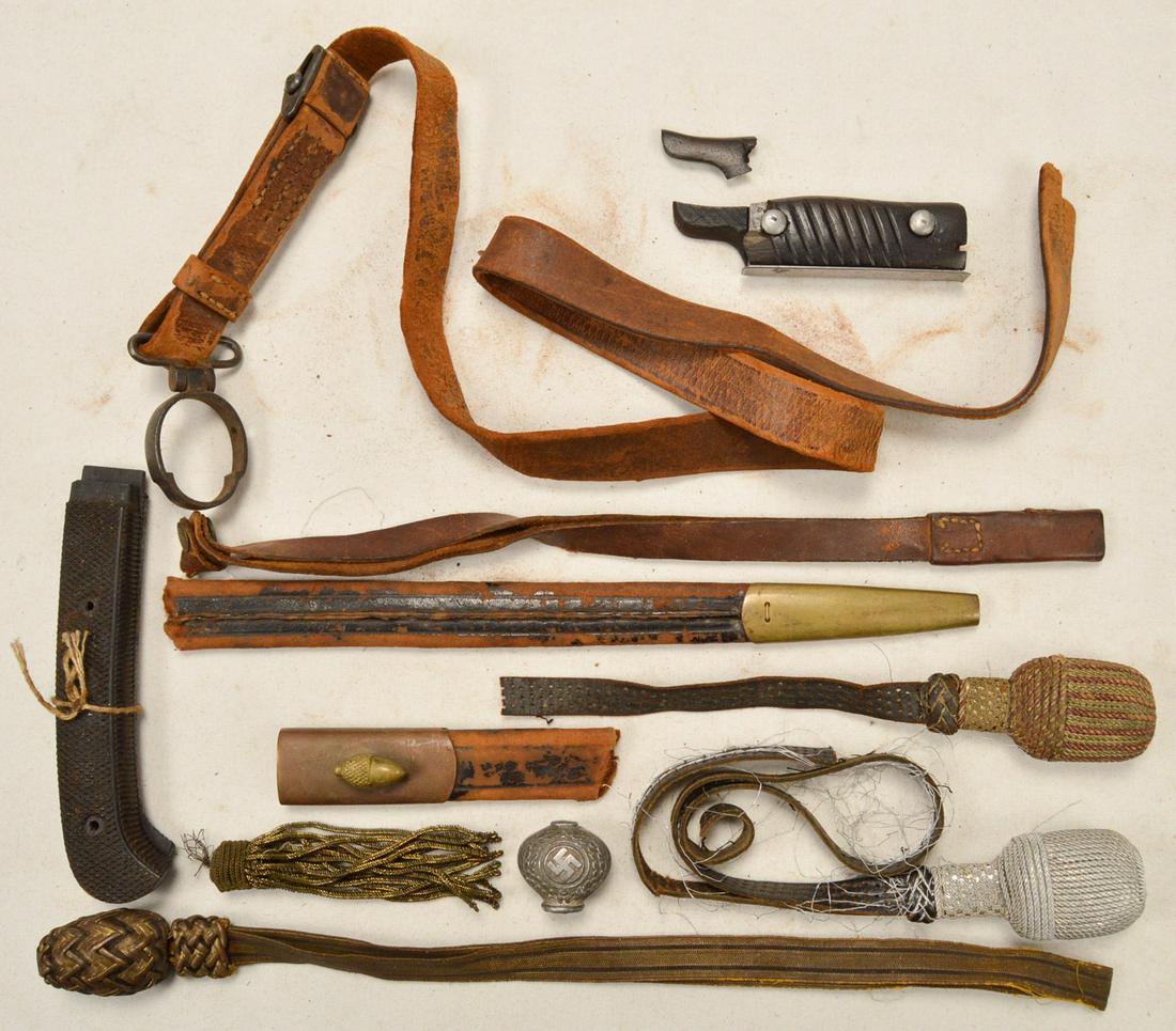 Lot of Misc. Weapon Accessories: Lot contains 3 dagger knots, a grip for a WWI German bayonet, a Nazi pommel, a broken sling attached to a barrel band, a broken bayonet scabbard, a pair of grips for a knife, and more. See photos.