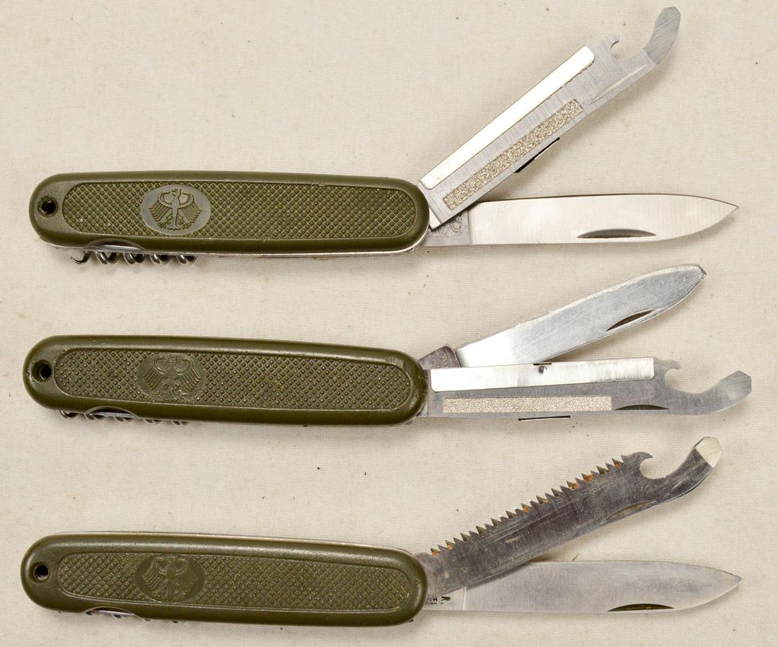 Lot of 3 West German Pocket Knives: Lot contains 3 West German pocket knives in the style of Swiss Army knives. All 3 knives have a green plastic handle with the Federal German eagle on one side. Ricassos of knives are marked "I.C.A.R./
