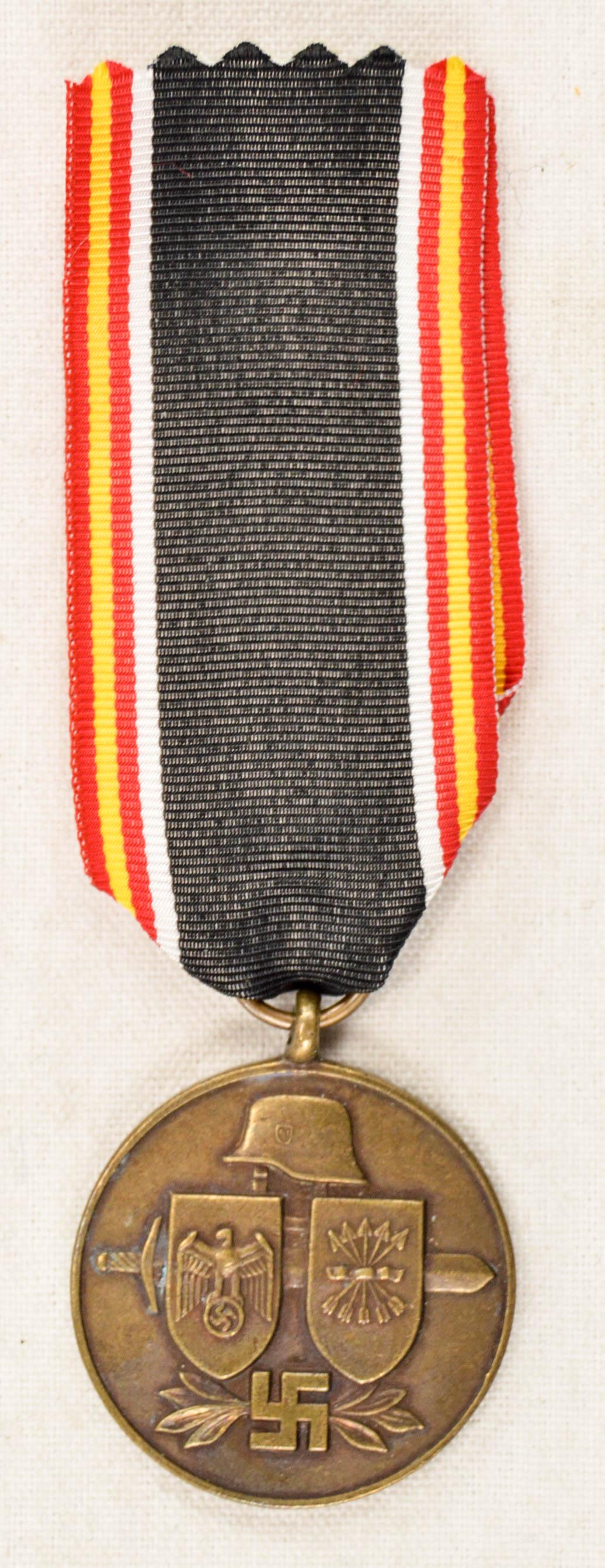 German WWII Spanish Blue Division 1941 Eastern: German World War II Spanish Blue Division 1941 Eastern Front Axis Decoration. Measures 1 1/4" in diameter. The front shows a German helmet with two shields and a sword. The reverse side reads ‘Divis