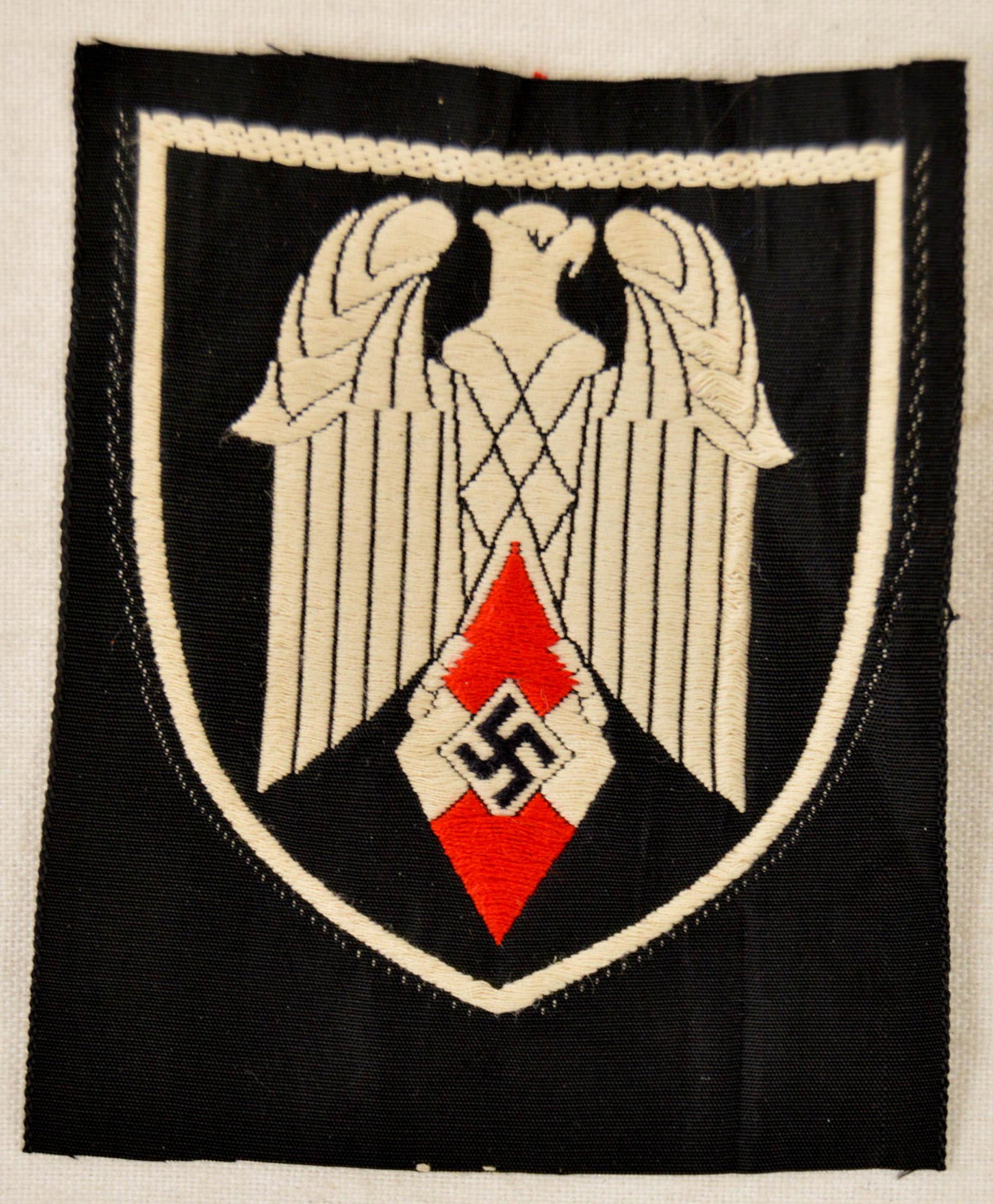 German WWII Hitler Youth HJ Standarte Flag Patch: German WWII Hitler Youth HJ Standarte Flag Bearers Patch. Measures 2 3/4" wide by 3 3/8” tall. The front shows a German eagle clutching a Hitler youth diamond in his talons. Machine embroidered bev
