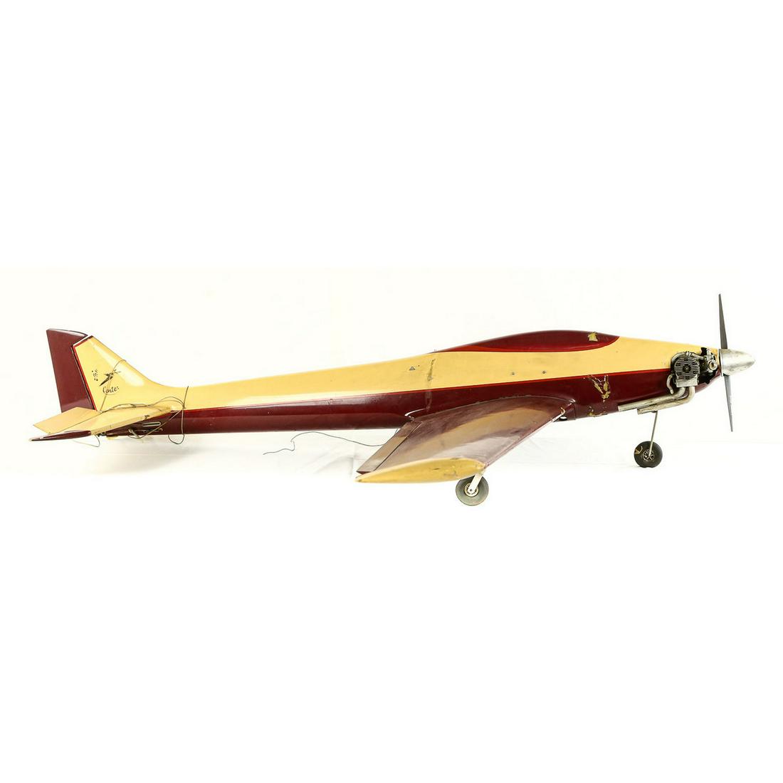 Large Radio Controlled Gas Powered Model Plane: A large wood and fiberglass model airplane powered by a large single cylinder (old style) carbureted nitro type fuel model engine. Inside it looks to have all the servo type mechs to handle the wing a