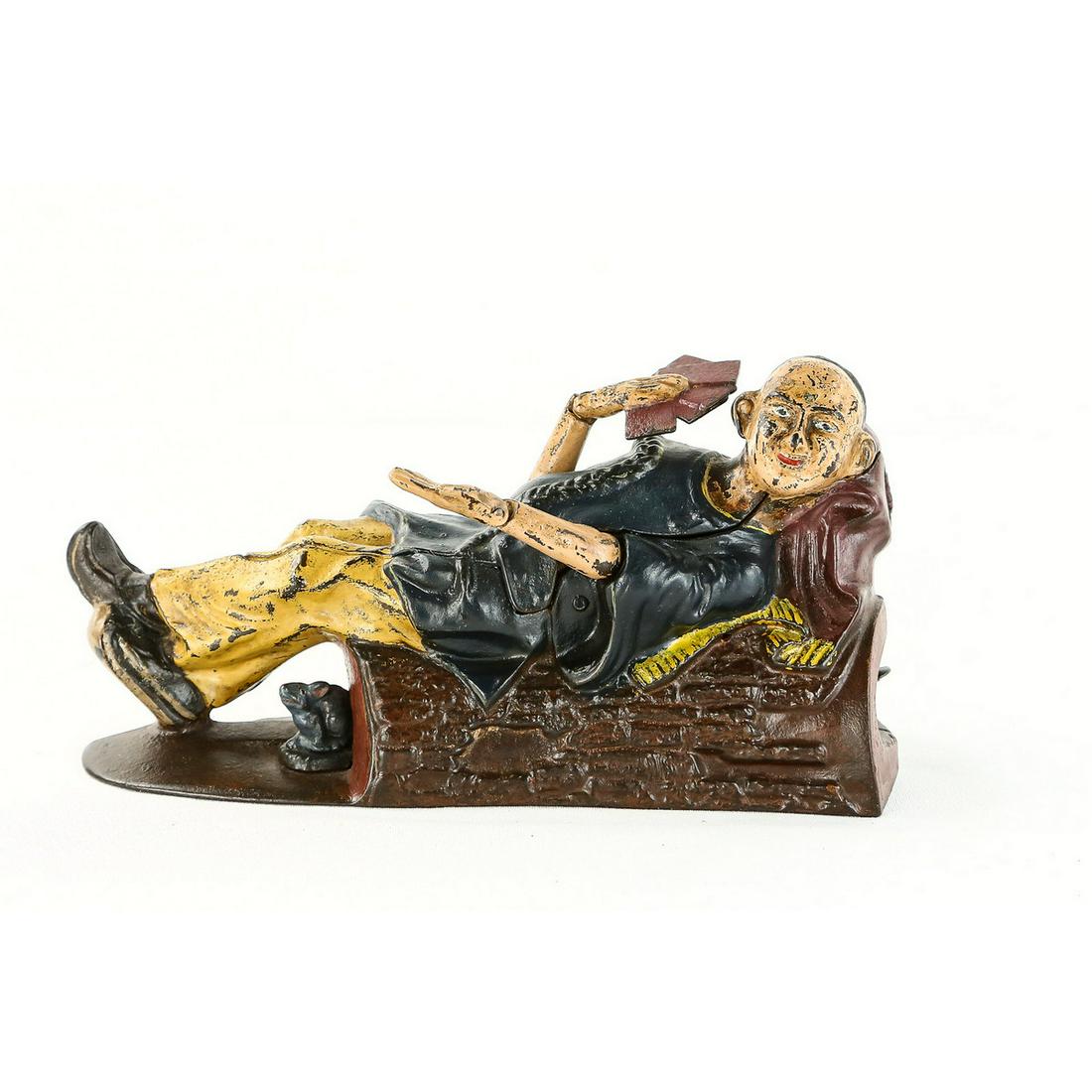J & E Stevens Reclining Chinaman CI Mech Bank: 1882 made by J&E Stevens Co, cast iron, reclining Chinaman mechanical bank, works, parts have been professionally repainted. Bottom base approx 2 9/16" x 8 3/8" Please note: A signed COA guaranteeing 
