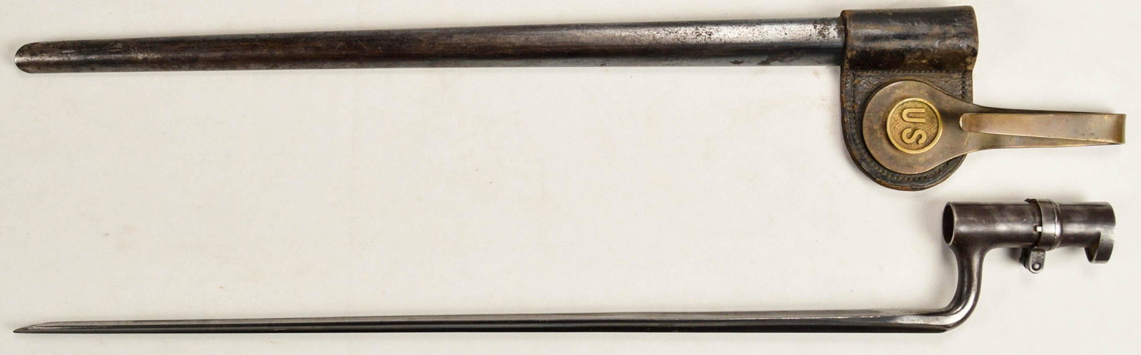 US M1873 Springfield 45-70 Bayonet with Sheath: US M1873 Springfield 45-70 Bayonet with Sheath. In good condition with minor wear. Bayonet stamped "US" on bottom of spike. Scabbard is in good condition with some fading on the brass holder. See phot