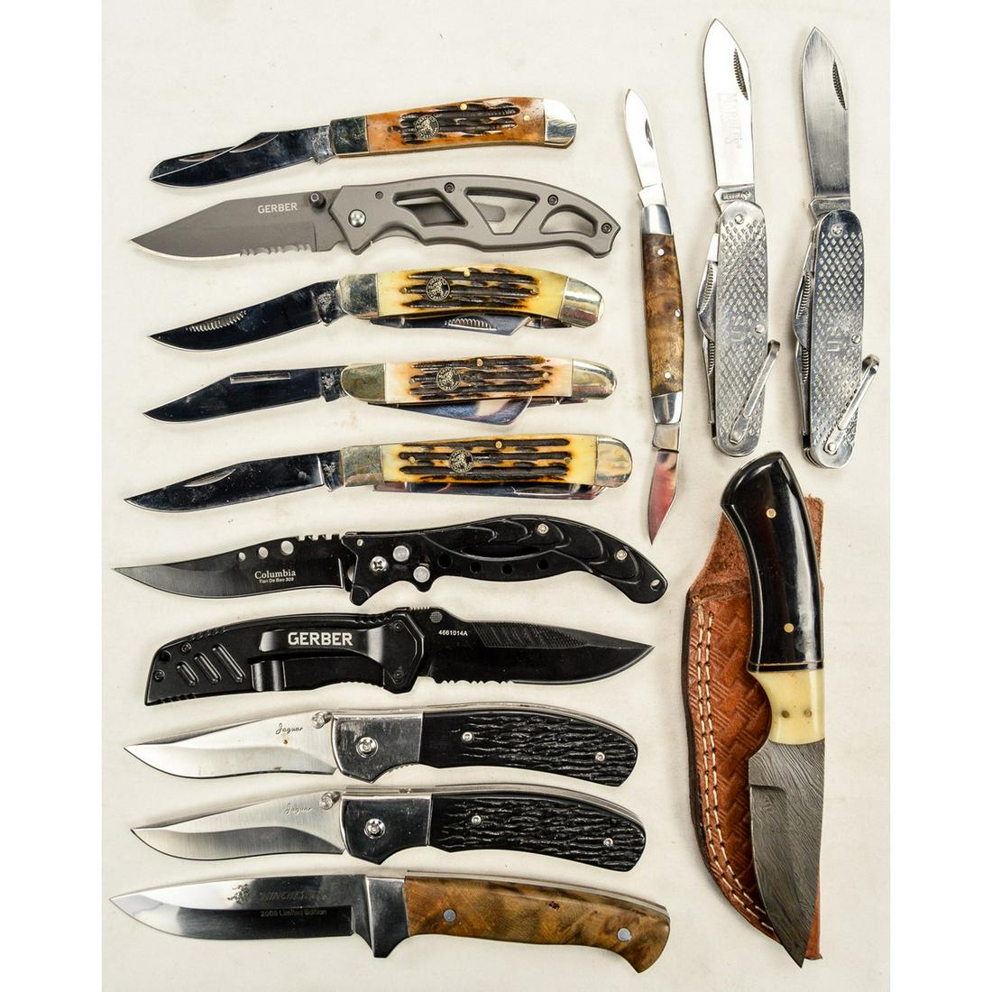 Display Case with 14 Knives: Display case with 12 folding knives and 2 fixed blade knives. 1 fixed blade comes with a leather sheath. Knives are made from various makers including Gerber, Winchester, White Tail Cutlery and more. 