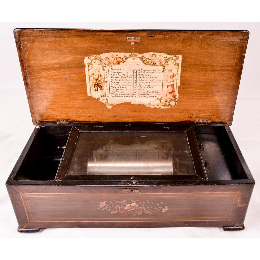 Swiss 24 Tune Cylinder Music Box: This untouched, as found machine has original finish on it's cabinet, which has numerous scrapes and dings. Top and front have inlaid borders, which are chipped and lifting in some areas. The top and