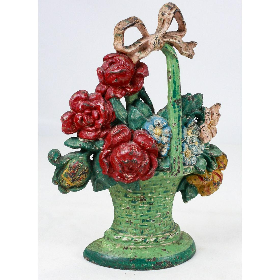 Vintage Flowers in Basket Doorstopper: Mixed flowers in basket with bow cast iron doorstopper. Most of the colors are still present with some wear from age. Good used condition, see photos.