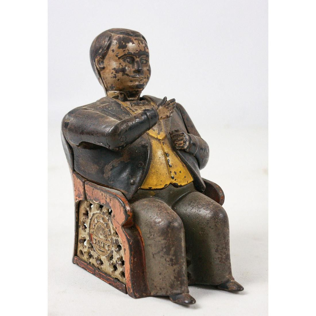 Tammany Hall Mechanical Coin bank: This bank depicts Boss Tweed pocketing illicit money for Tammany Hall. It is in well worn used condition. There is oxidation throughout the metal. The paint is faded but original. You put the money in