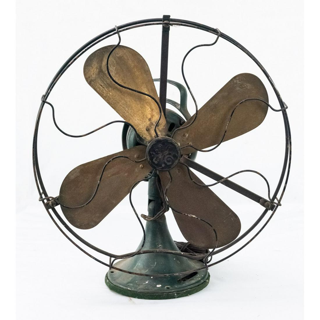 Vintage General Electric Table Fan: A General Electric fan with 4 brass blades. Fan base is painted green and fan swivels when blowing. Fan cage has worn paint and features "GE" in script letters in center. Overall fair to good conditio