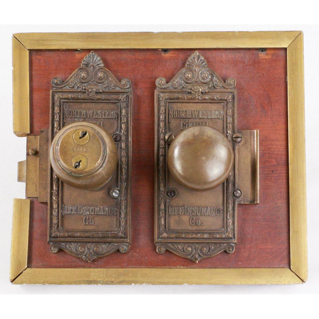 Northwestern Mutual Insurance Door Knobs: Pair of Northwestern Mutual brass door knobs mounted on a wooden bard for display. These were taken form the life insurance branch of the Loyalty Building that held important documents, and were used 
