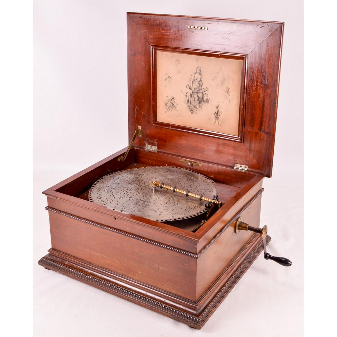 Regina 15.5" Music Box: Regina table top single comb music box in a mahogany cabinet with raised lid. No broken teeth in the comb. Winds and plays well. Includes 6 discs. Measures 22" wide, 19.5" deep, 12" tall