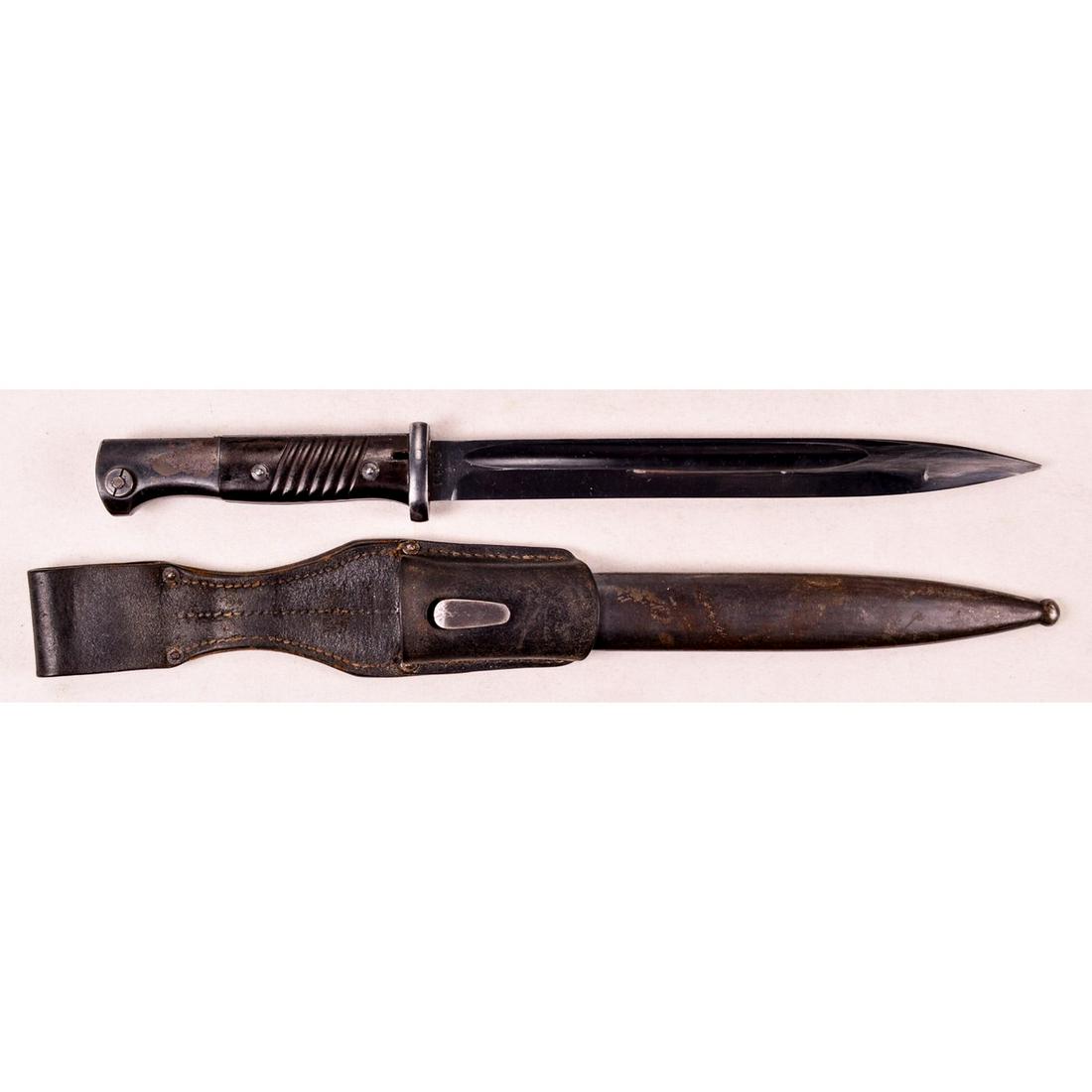 WWII German K98k Bayonet: A WWII German bayonet for a K98k rifle. Bayonet has matching scabbard and original frog. Ricasso is marked "41 cos" on one side and numbered "1405f". 10" blade retains majority of blued finish with so