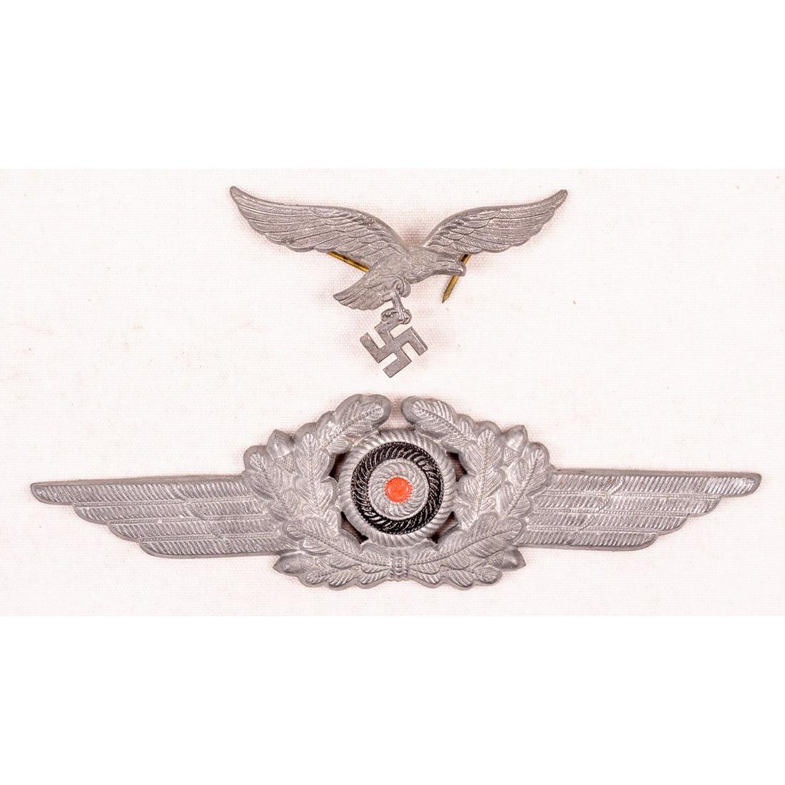 WWII German Luftwaffe Cap Badge & Cockade: A Luftwaffe cap badge and cockade for a peaked visor cap. Both pieces retain their pins though cap badge has an awkwardly bent pin. Both pieces show some minor wear and are in overall very good condit