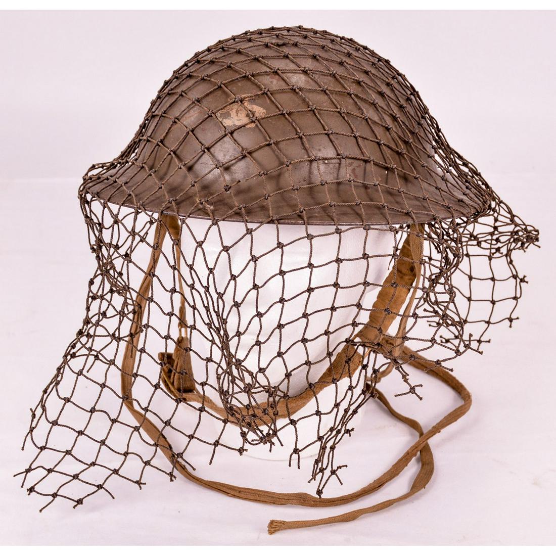 WWII British Mark Series Tommy Helmet: With original liner and chin strap. Interior is battleship gray with loose camo netting.