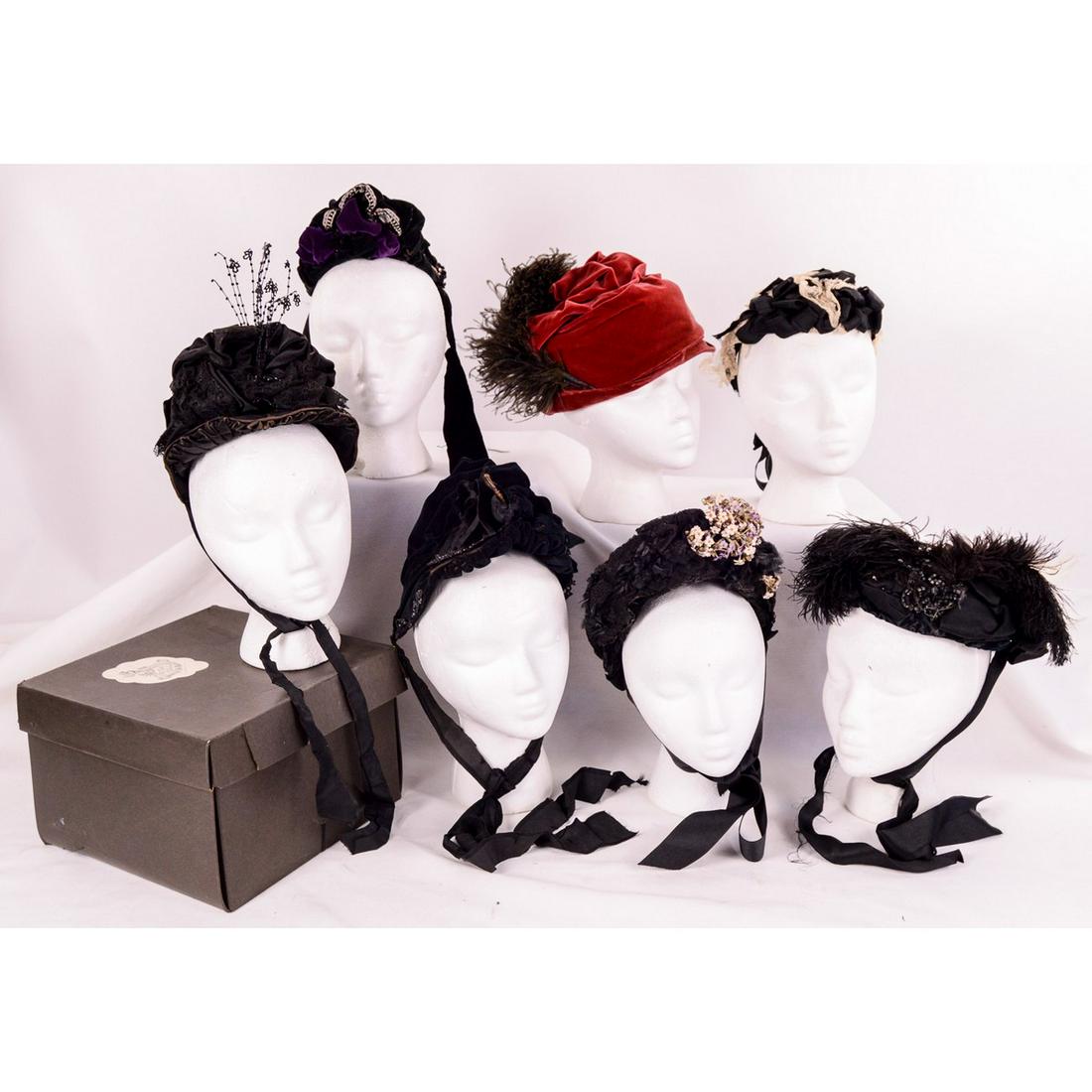 7 Hats 1860's through 1870's: Lot includes 7 hats, mostly bonnets. All in very good condition for their age. Highlights include tiny off white lace hat covered in black satin bows. Maroon velvet hat with black ostrich feather. Ass
