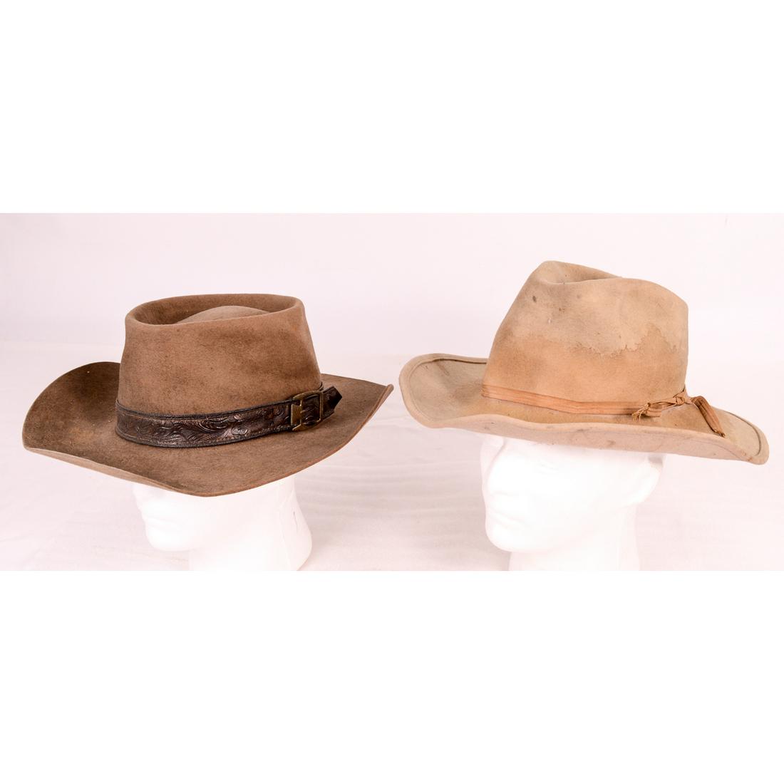 Two Vintage Beaver Felt Cowboy Hats: Vintage Cowboy Hats. Largest Brown Hat 14 1/2" x 13 1/2" Large size with leather embossed hat band has a cut on the side. The light tan hat has stains all the way around. No makers names. See photos.