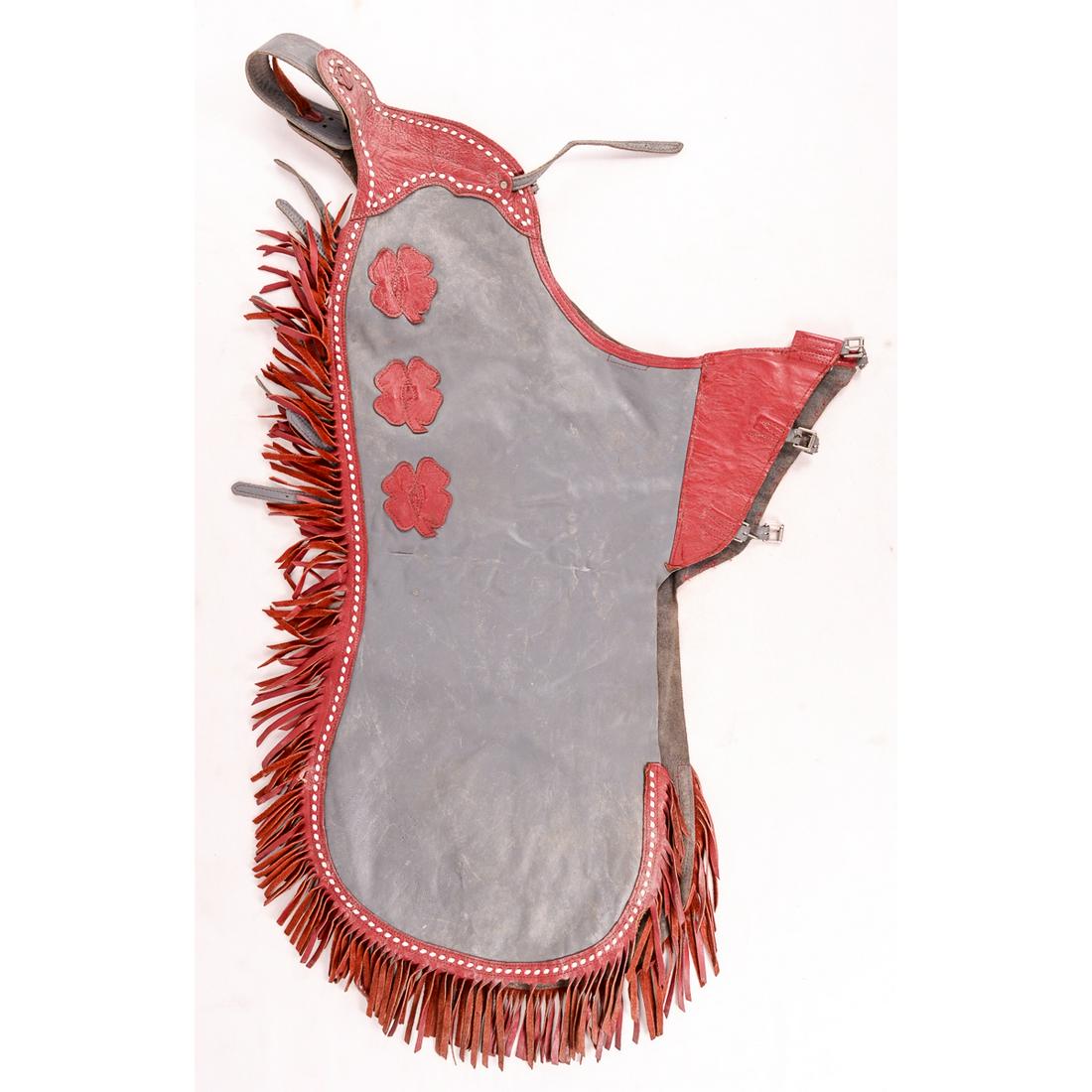 Vintage Chrisman Rodeo Chaps Gray with Red Trim: Vintage Chrisman Rodeo Chaps. 40" L x 46" W. In good condition. Gray and red trim with clovers. Includes a belt with small buckles. Leather strap has a small tear at one of the holes. Visit the local 
